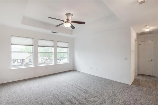an empty room with a window and a fan