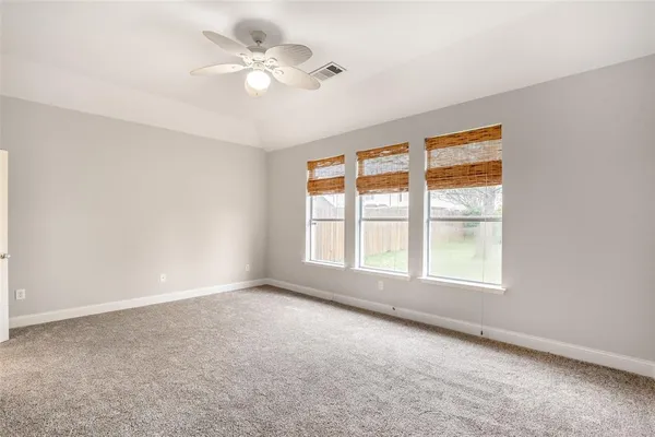 an empty room with fan and windows