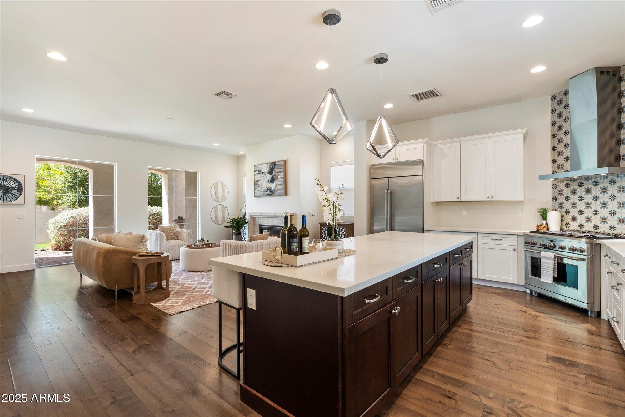 640 West Echo Lane Phoenix, AZ 85021 - Photo 11 of 55 a open kitchen with stainless steel appliances granite countertop a sink dishwasher a stove a dining table and chairs with wooden floor