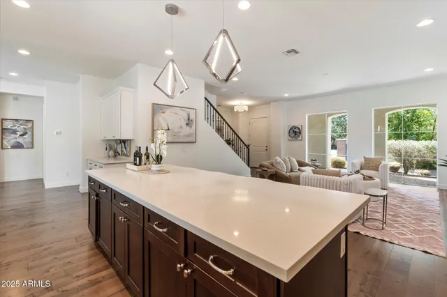 a living room with stainless steel appliances kitchen island a table chairs and a view of living room