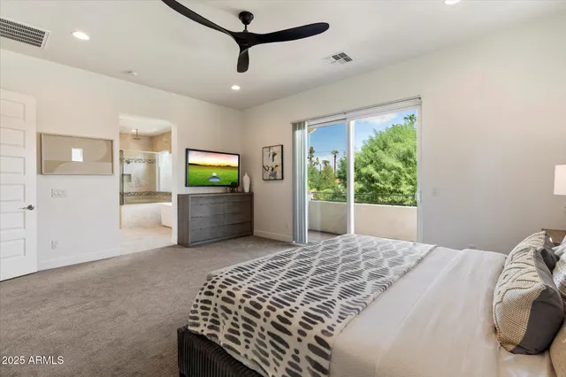 a bedroom with a bed and a flat screen tv