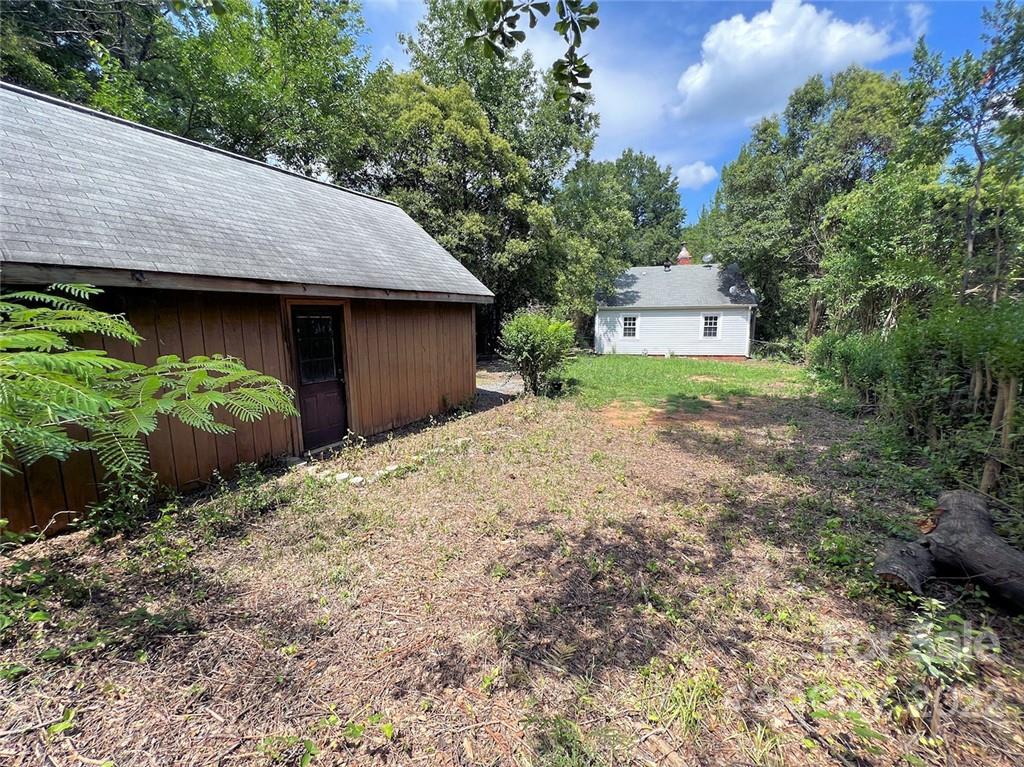 1322 Shamrock Drive Charlotte, NC 28205 - Photo 11 of 21 a backyard of a house with large trees and a wooden fence