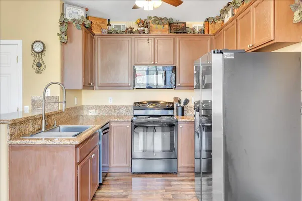 a kitchen with stainless steel appliances granite countertop a sink stove and refrigerator