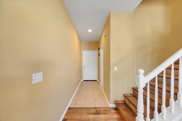 a view of a hallway with wooden floor and staircase