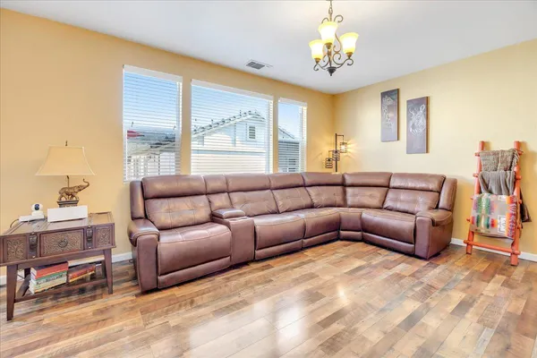 a living room with furniture a chandelier and a window