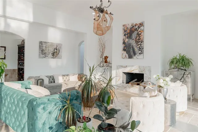 a living room with furniture a fireplace and a potted plant