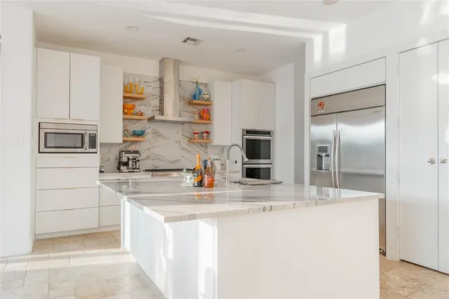 a kitchen with stainless steel appliances granite countertop a sink and a refrigerator