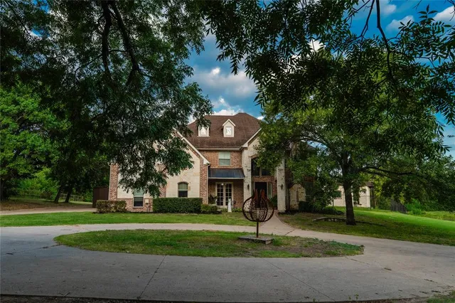 a front view of a house with a yard and palm trees
