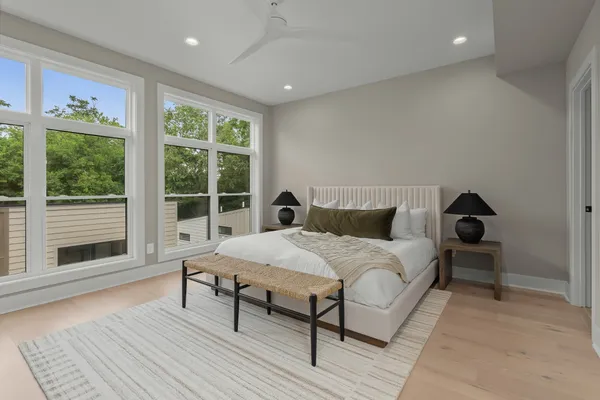 a bed sitting in a spacious bedroom next to a window