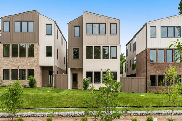 a view of a big house with a yard in front of it