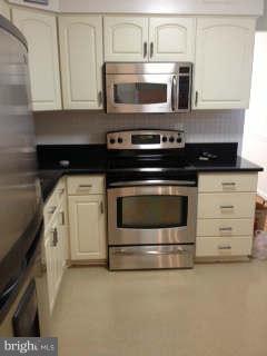 13212 Tamarack Road Silver Spring, MD 20904 - Photo 2 of 28 a kitchen with granite countertop a stove microwave and cabinets