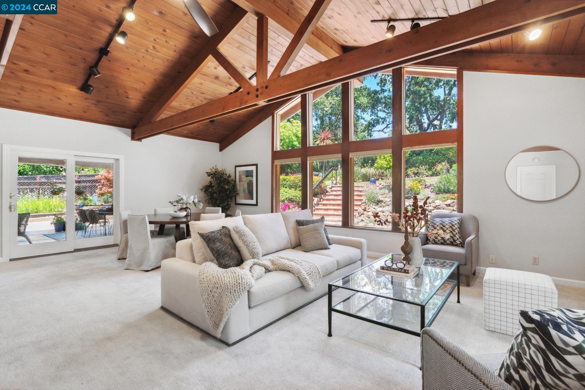 a living room with furniture a ceiling fan and a large window