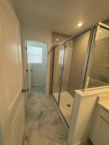 a bathroom with a glass door shower and a sink