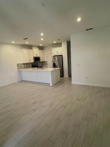 a view of kitchen with kitchen island granite countertop a large counter top stainless steel appliances and cabinets