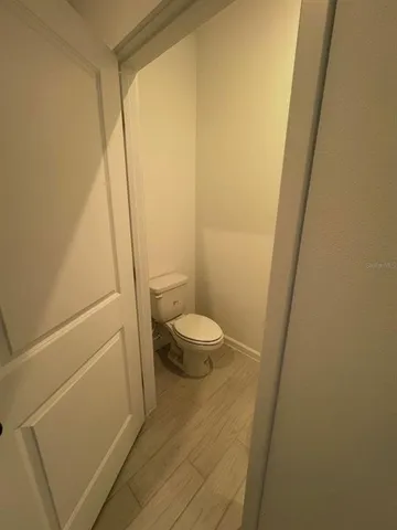 a bathroom with a granite countertop sink and a toilet