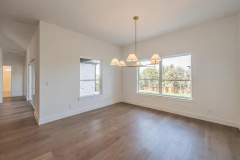 a view of empty room with wooden floor and outdoor view