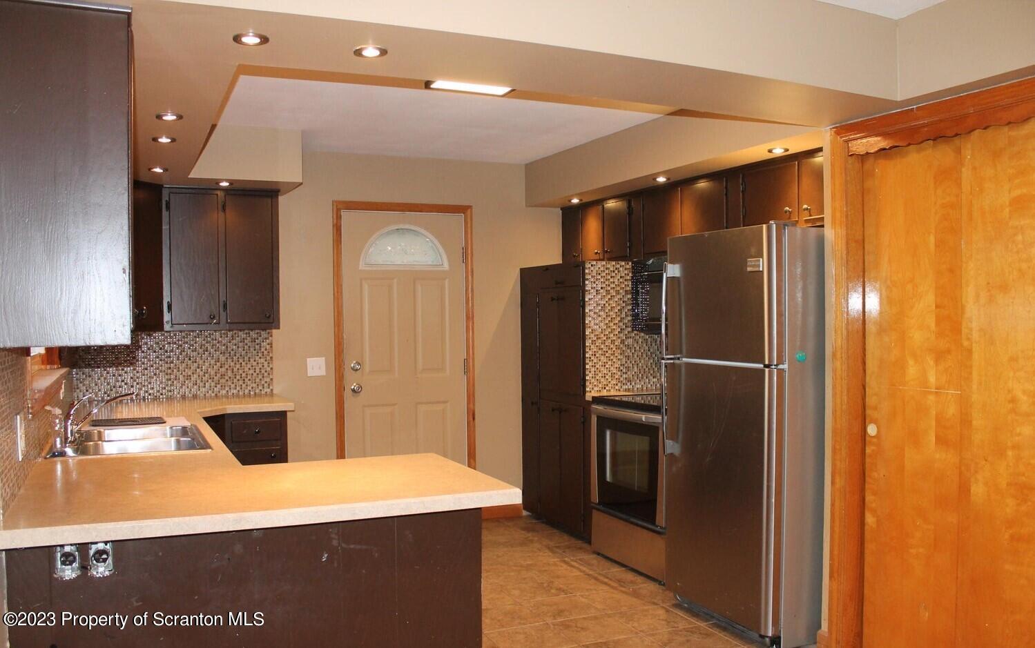 707 Hollenback Street Moosic, PA 18507 - Photo 5 of 20 a kitchen with a refrigerator and a sink