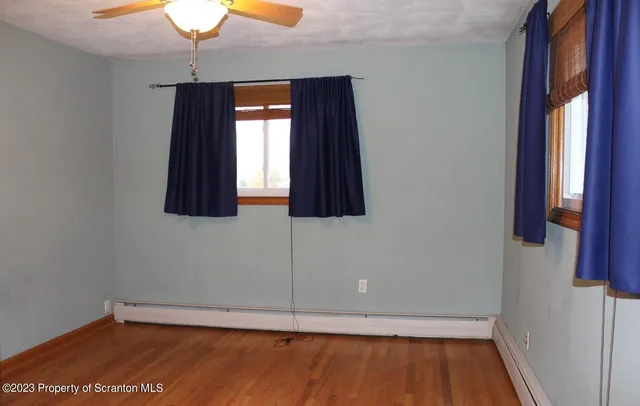 a view of a small space with wooden floor and a window