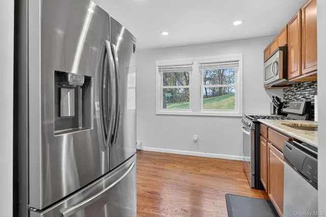a kitchen with stainless steel appliances granite countertop a refrigerator a stove and a refrigerator