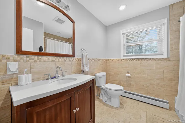 a bathroom with a sink toilet and a mirror