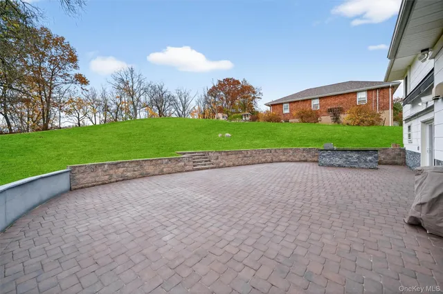 a view of a house with a yard and large tree