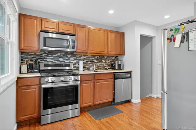 a kitchen with stainless steel appliances granite countertop a stove microwave and refrigerator