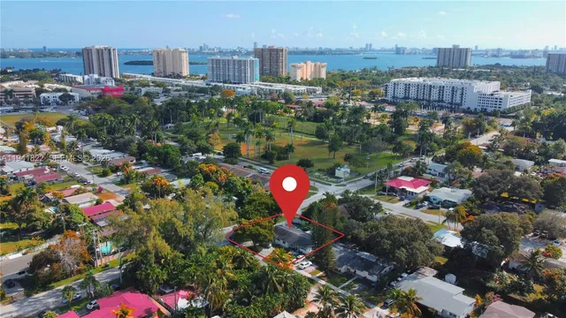 a white house covered with tall trees