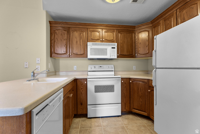 389 North Main Street St. George, UT 84770 - Photo 31 of 44 Kitchen with white appliances, wood finish cabinetry, light countertops, and a peninsula