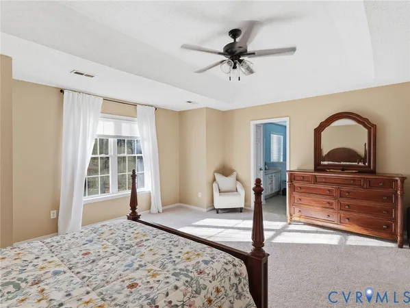 a bedroom with a bed lamp and a large window