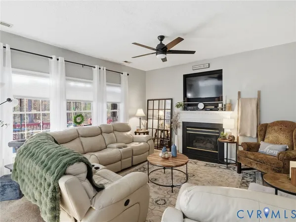a living room with furniture a flat screen tv and a fireplace