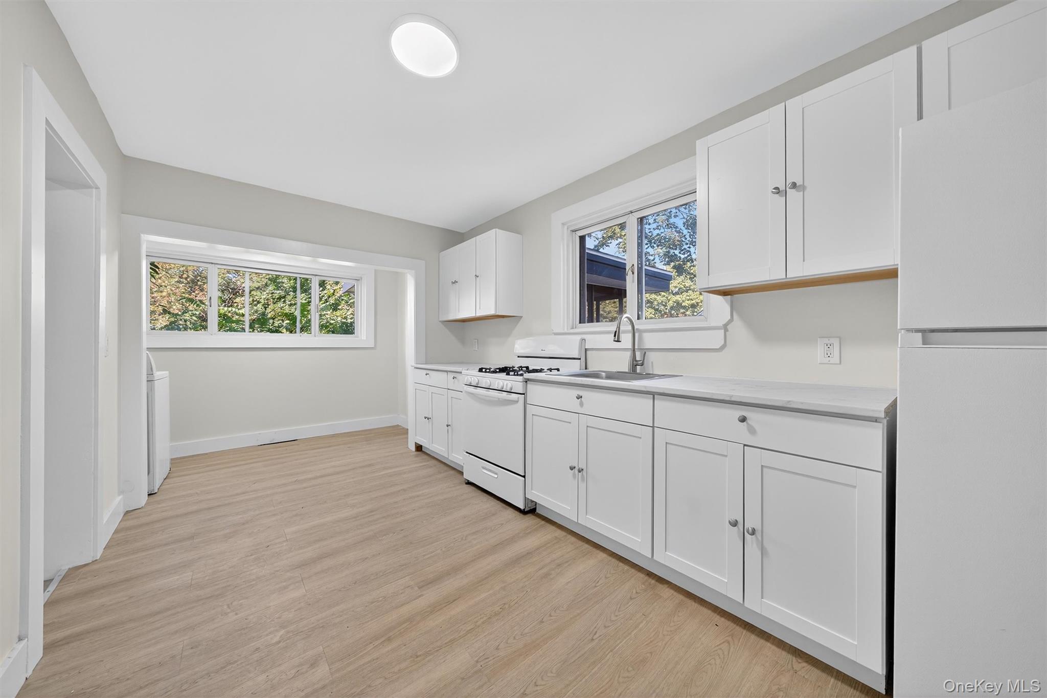 26 Ridge Street Middletown, NY 10940 - Photo 11 of 22 a kitchen with granite countertop white cabinets and white appliances