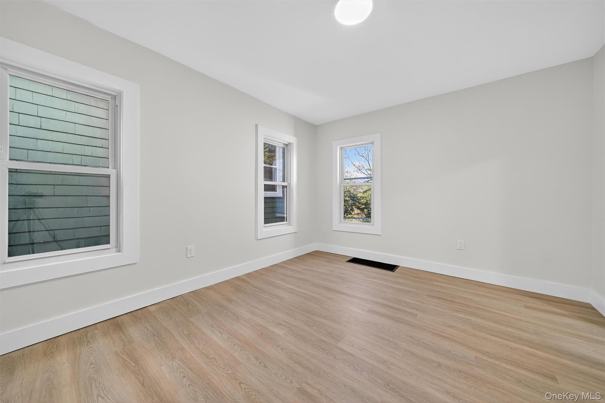 26 Ridge Street Middletown, NY 10940 - Photo 8 of 22 a view of an empty room with wooden floor and a window