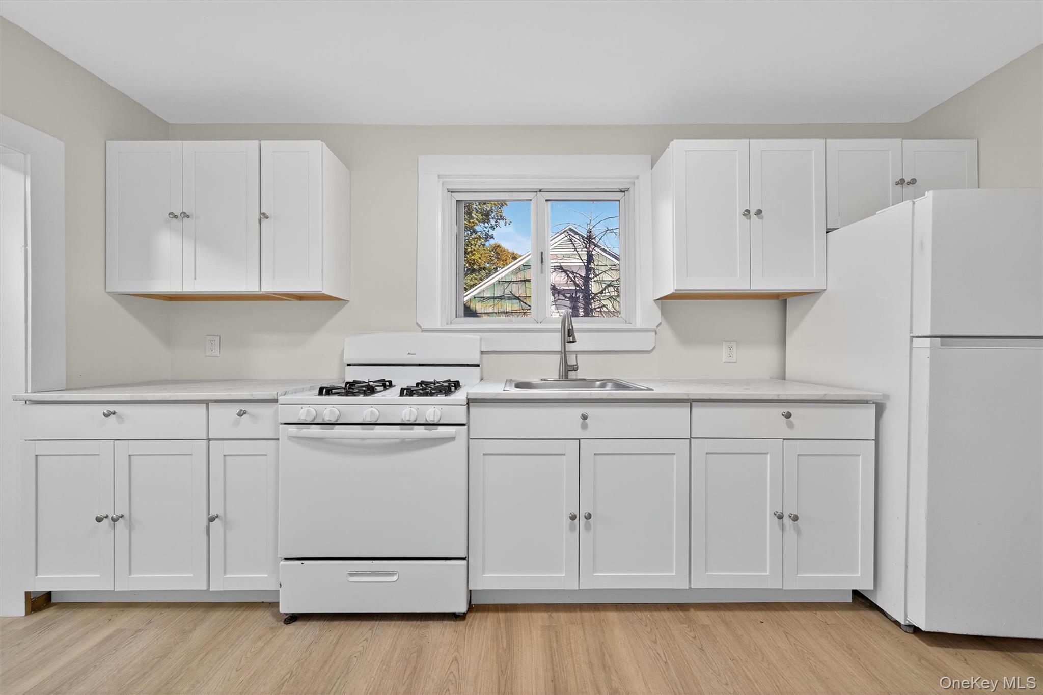 26 Ridge Street Middletown, NY 10940 - Photo 10 of 22 a kitchen with granite countertop white cabinets and white appliances