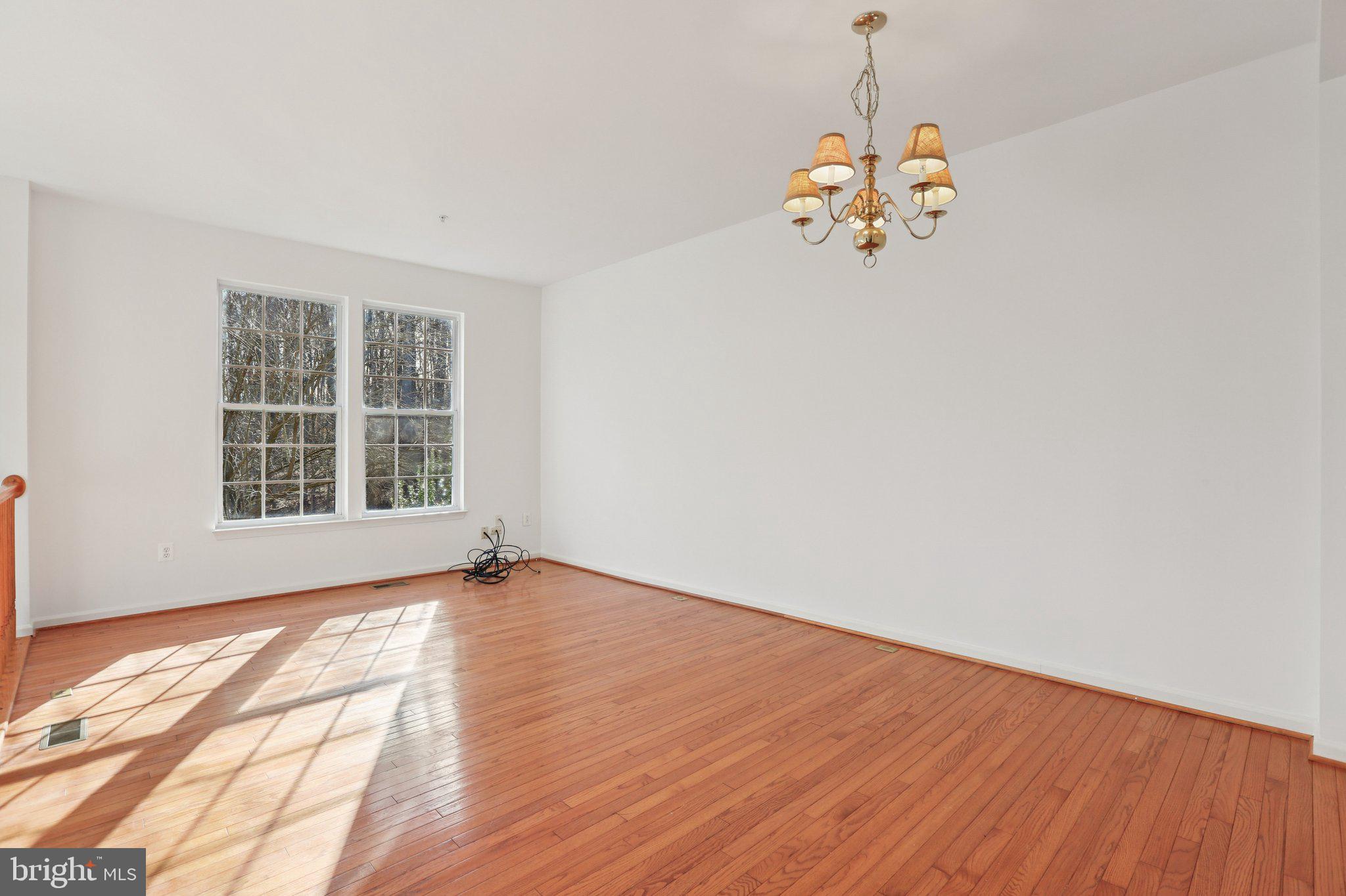 8046 Pennington Drive Laurel, MD 20724 - Photo 4 of 12 a view of an empty room with wooden floor and a window