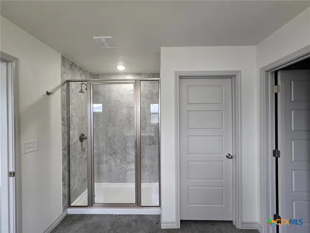 a bathroom with a glass shower door