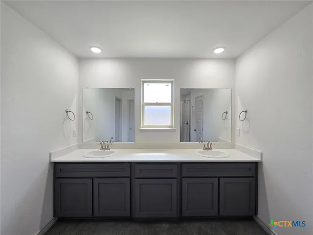a bathroom with double vanity sinks and a mirror