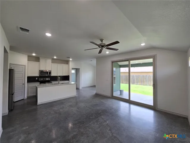 a view of large kitchen with a sink and a refrigerator