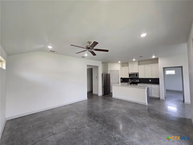 a view of a kitchen with a sink and a refrigerator