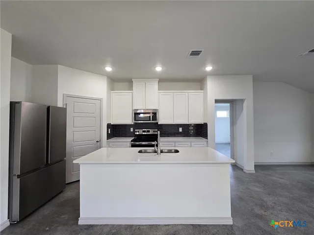 a kitchen with stainless steel appliances a refrigerator sink and microwave