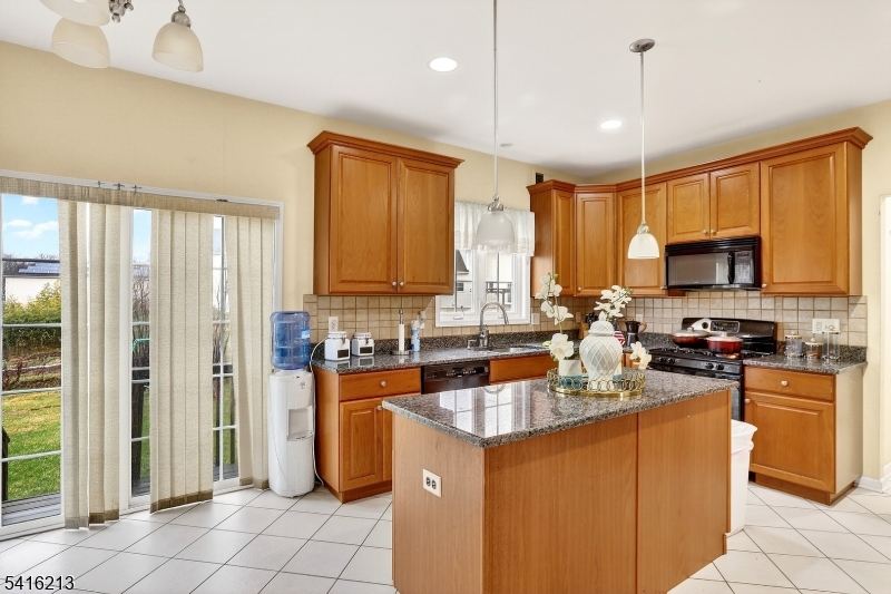 127 Churchill Avenue Somerset, NJ 08873 - Photo 17 of 33 a kitchen with stainless steel appliances granite countertop a stove top oven a sink dishwasher a refrigerator and a cabinets with wooden floor