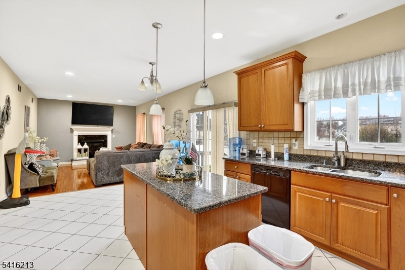 127 Churchill Avenue Somerset, NJ 08873 - Photo 18 of 33 a kitchen with a stove a sink a kitchen island with a dining table and chairs