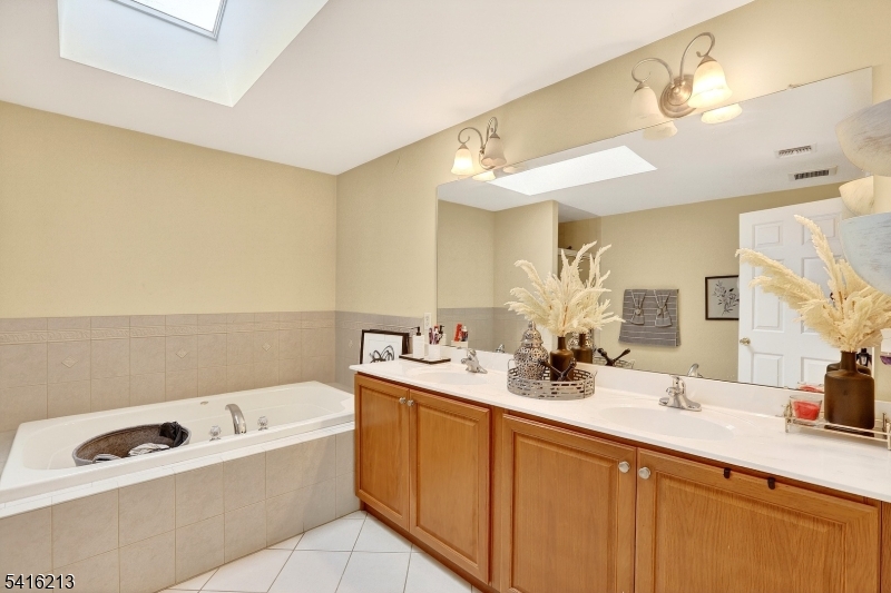 127 Churchill Avenue Somerset, NJ 08873 - Photo 22 of 33 a bathroom with a tub a sink and mirror