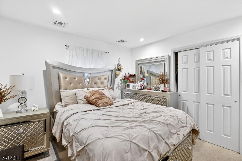 127 Churchill Avenue Somerset, NJ 08873 - Photo 25 of 33 a bedroom with a large bed and a chandelier