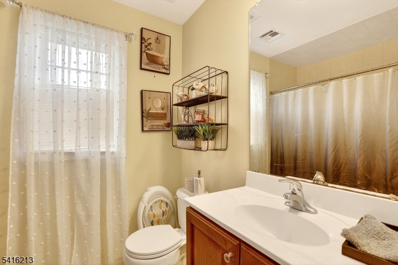 127 Churchill Avenue Somerset, NJ 08873 - Photo 26 of 33 a bathroom with a sink vanity mirror and a toilet