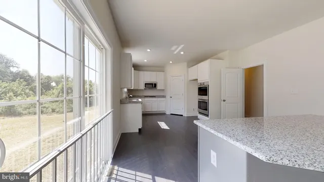 a kitchen with granite countertop white cabinets and stainless steel appliances