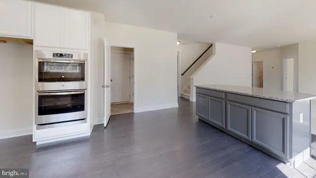 a view of a hallway with wooden floor and windows