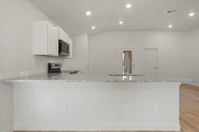 a view of a kitchen with a sink and a large window