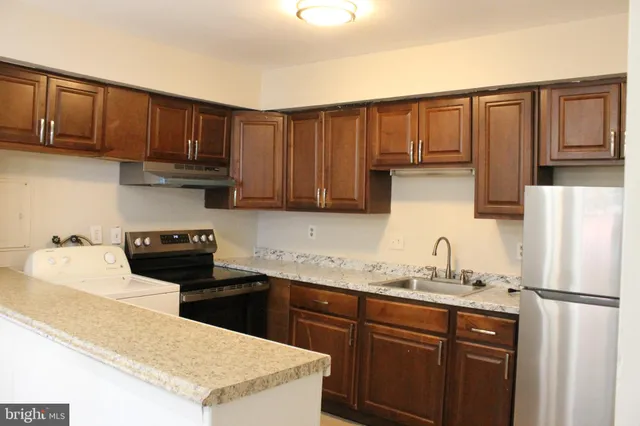 a kitchen with stainless steel appliances granite countertop a refrigerator sink and cabinets