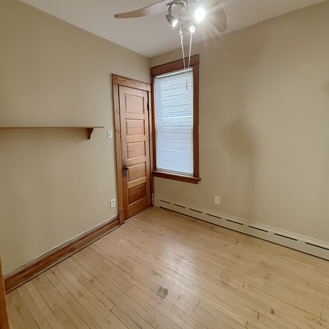 2133 West Grace Street, Unit 2 Chicago, IL 60618 - Photo 15 of 22 an empty room with wooden floor fan and windows