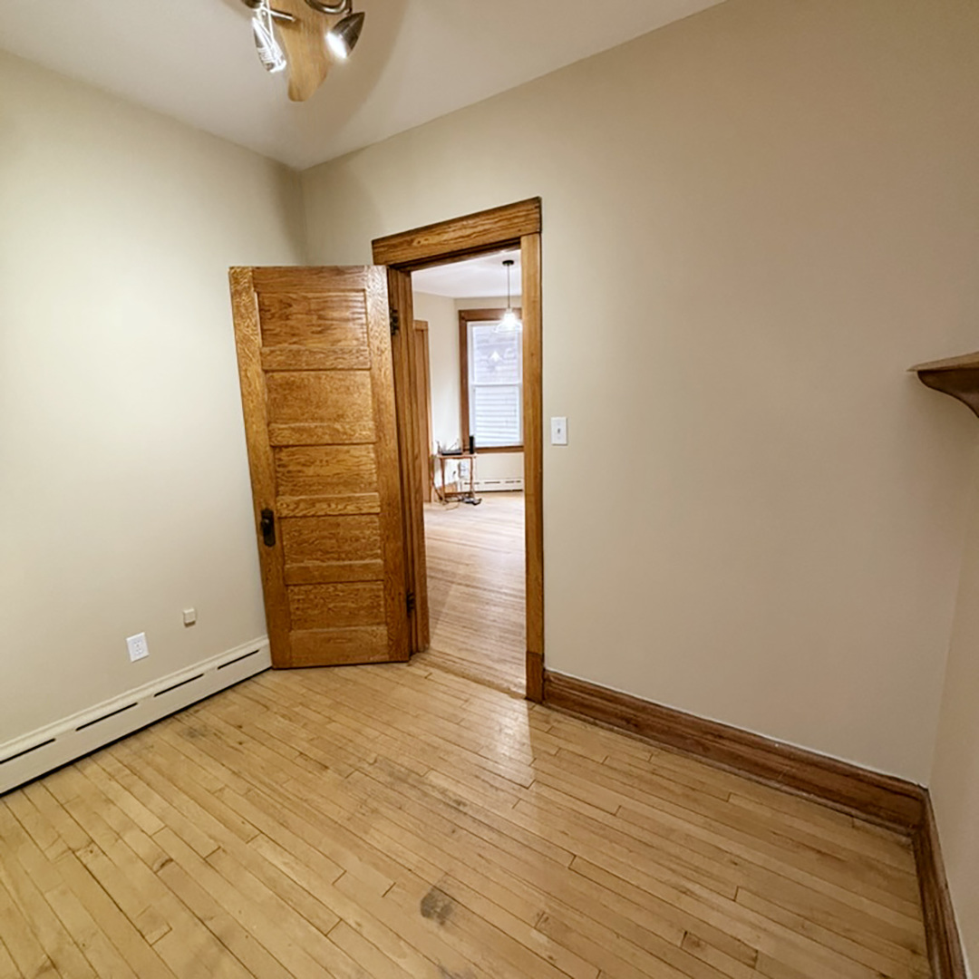 2133 West Grace Street, Unit 2 Chicago, IL 60618 - Photo 16 of 22 an empty room with wooden floor and fan